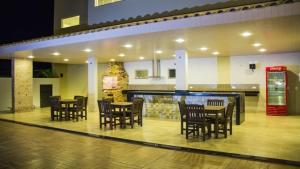 a restaurant with tables and chairs and a soda machine at Hotel Baeza in Goiatuba