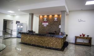 un vestíbulo con un mostrador con relojes en la pared en Hotel Baeza, en Goiatuba