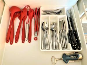 a drawer full of utensils sitting on a shelf at Appartements Rue Sarret XXL in Angers