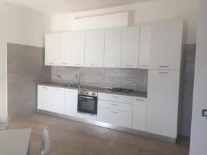 a white kitchen with white cabinets and a stove at Appartamento dei nonni di Gio e Cry in Sperlonga