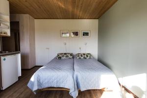 een slaapkamer met een bed en een houten plafond bij Resort Naaranlahti in Punkaharju