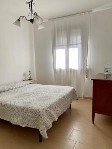 a white bedroom with a bed and a window at Casa Ester in Preganziol