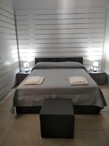 um quarto com uma cama grande com 2 mesas e 2 candeeiros em B&B Da Luca em Grottaminarda