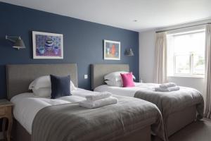 two beds in a room with blue walls at The Stump in Cirencester