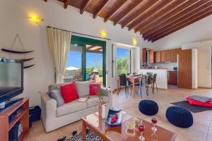 a living room with a couch and a tv and a table at Villa Anna Maria by Villa Plus in Pírgos Psilonérou