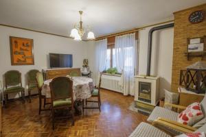 a living room with a table and chairs and a fireplace at Il Marangon in Prato Carnico
