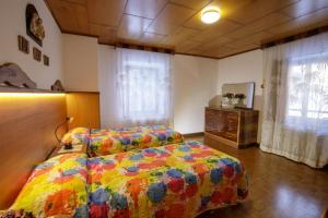 a bedroom with a bed with a colorful comforter at Il Marangon in Prato Carnico