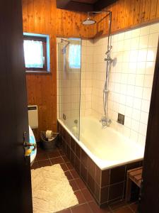 a bathroom with a tub and a glass shower at Ferienhaus Regeneration bayerischer Wald in Regen +21 photos
