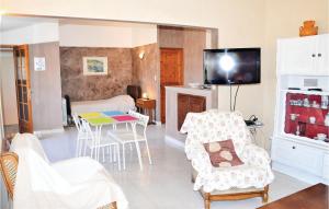 a living room with a table and chairs and a tv at Gorgeous Apartment In Sault With Kitchenette in Sault-de-Vaucluse