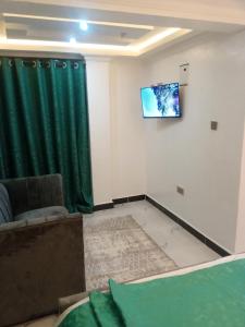 a living room with a couch and a tv on a wall at Muka homes in Naivasha