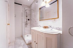 uma casa de banho branca com um lavatório e um chuveiro em Bright and cozy-1Bd 1Bth & 2Bd 1Bth- La Giralda em Sevilha