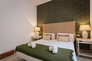 um quarto com uma grande cama branca e duas mesas em Bright and cozy-1Bd 1Bth & 2Bd 1Bth- La Giralda em Sevilha