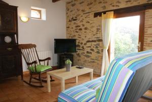 a living room with a couch and a tv and a chair at Logis Du Patis Roux in Nort-sur-Erdre