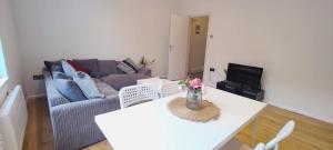 a living room with a couch and a table at Spacious 3 Bed Flat near Liverpool street, Spitalfields in London