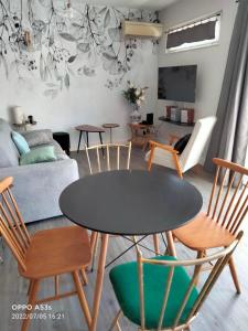 - un salon avec une table et des chaises dans l'établissement La terrasse Majorelle., à Le Passage