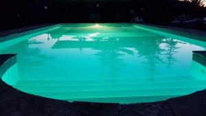 una piscina iluminada por la noche con luces verdes en Antico Casale '700 appartamento GIRASOLE, en Umbertide