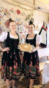 zwei Mädchen in Kleidern mit einem Teller Essen in der Unterkunft Karczma Kubalonka in Istebna