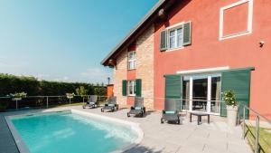 une maison avec une piscine à côté d'un bâtiment dans l'établissement Casa Vecchio Mulino, à Alba