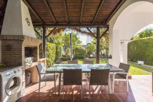 une terrasse avec une table, des chaises et une cuisinière dans l'établissement OleHolidays Balcones de Bellavista, à Estepona