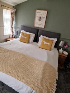 a bedroom with a large bed with two pillows at The Foresters Arms in Tarporley