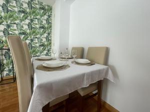 einen Tisch mit 2 Stühlen und einem weißen Tischtuch in der Unterkunft El valluelo in Almazán