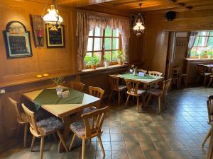 a restaurant with two tables and chairs and windows at Gasthaus und Pension Koch in Cursdorf