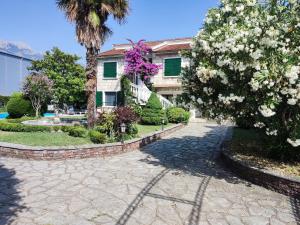 a walkway in front of a building with trees and flowers at Leisure House Jovovic in Bar