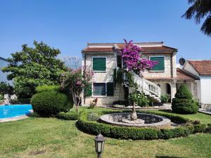 a house with a fountain in front of a yard at Leisure House Jovovic in Bar