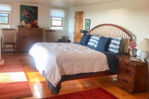 a bedroom with a large bed with blue pillows at Valleys & Views in Nantucket