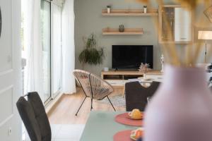 a living room with a table and chairs and a television at Holiday home Paligan in Solin