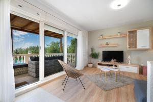 a living room with a large window and a television at Holiday home Paligan in Solin