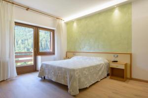 a bedroom with a bed and a large window at Hotel Diana in Auronzo di Cadore