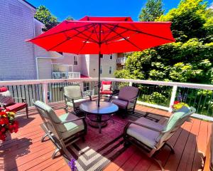 a patio with chairs and a table with a red umbrella at Charlotte's Rose Inn in Charlottetown