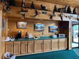 Boulder Bear Motor Lodge في Boulder Junction: مطبخ في كابينة خشب مع عناصر حيوانية على الحائط