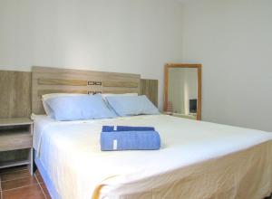 een groot wit bed met een blauwe doos erop bij Otimo Apto a 200m - Praia das Pitangueiras Guaruja in Guarujá +31 foto's