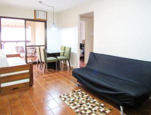 een woonkamer met een bank en een tafel bij Otimo Apto a 200m - Praia das Pitangueiras Guaruja in Guarujá