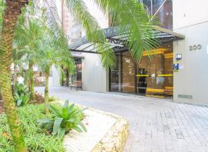 een palmboom voor een gebouw bij Otimo Apto a 200m - Praia das Pitangueiras Guaruja in Guarujá