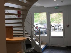 una escalera de caracol en una casa con puerta de cristal en Joli petit studio au bord du lac en Le Bourget-du-Lac