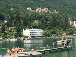 a group of people on a dock in a lake at Joli petit studio au bord du lac in Le Bourget-du-Lac