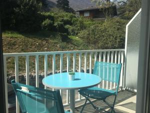- Balcón con mesa azul y 2 sillas en Joli petit studio au bord du lac en Le Bourget-du-Lac