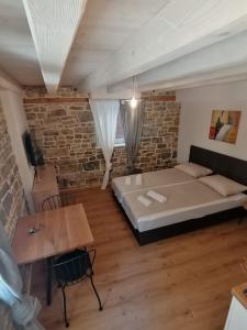 1 dormitorio con cama y pared de ladrillo en GG art apartments II en Piran