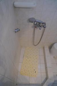 a shower with a yellow rug in a bathroom at Beach Side Apartments in Dhrepanon