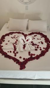 um bolo em forma de coração com cisnes e rosas numa cama em Pousada Cachoeira em Serra Negra