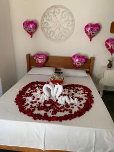 a bed with a heart made out of roses at Pousada Cachoeira in Serra Negra