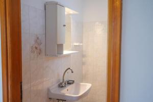a bathroom with a white sink and a cabinet at Beach Side Apartments in Drepana