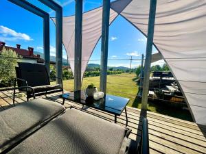 a patio with a table and chairs and large windows at MEGA in Prvačina