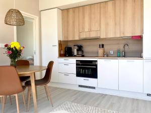 uma cozinha com armários brancos e uma mesa de madeira em Apartment Adventure & Sea - Top Floor em Kalajoki