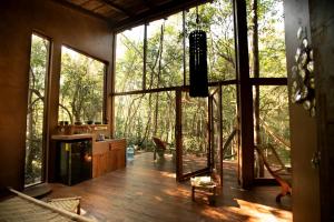 a living room with a large window and a view of the forest at OJO DE ÁRBOL, boutique cabin in the real jungle in Tulum