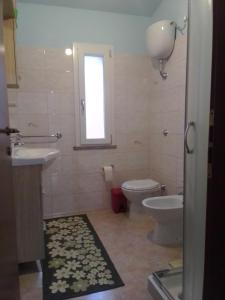 baño con aseo y lavabo y ventana en Casa Vacanze, en Santa Caterina