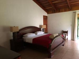 a bedroom with a bed with a red blanket at Parque Natural Ixpanpajul in Santa Elena